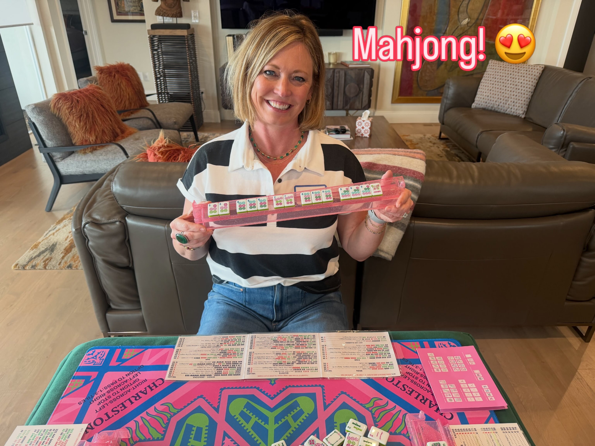 A player showing her winning Mahjong hand on a pink rack